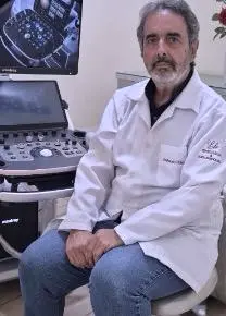 Dr. Haroldo sentado ao lado do aparelho de ultrassom